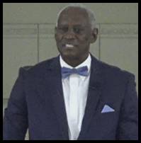 A person in a suit and bow tie

Description automatically generated